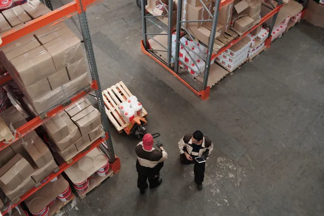 High angle view of warehouse workers organizing inventory with pallets and shelves. How a modular storage installation actually unfolds, week by week
