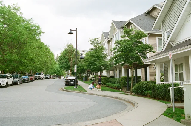 Charming Vancouver street with families enjoying a day outdoors among lined trees and houses. Urban community scene. Vancouver laneway house rental rules: permits, rent, deposits and short stays