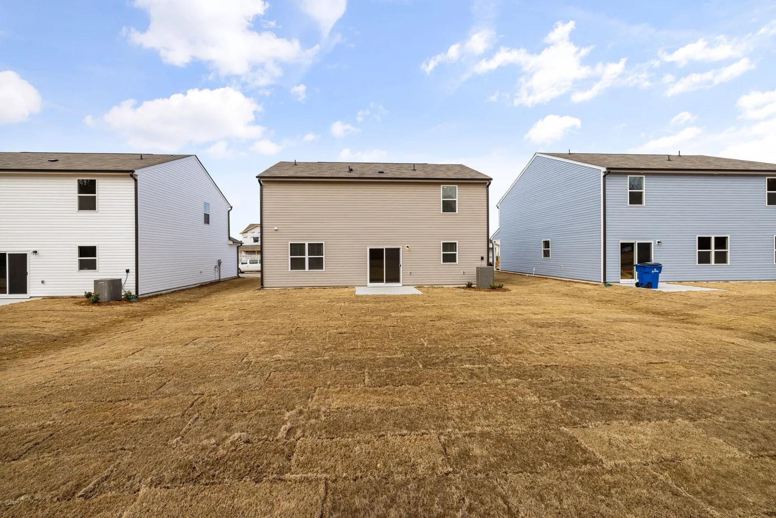 A row of modern suburban homes with freshly laid dry lawns under a bright sky. Laneway house or basement suite: how your lot decides