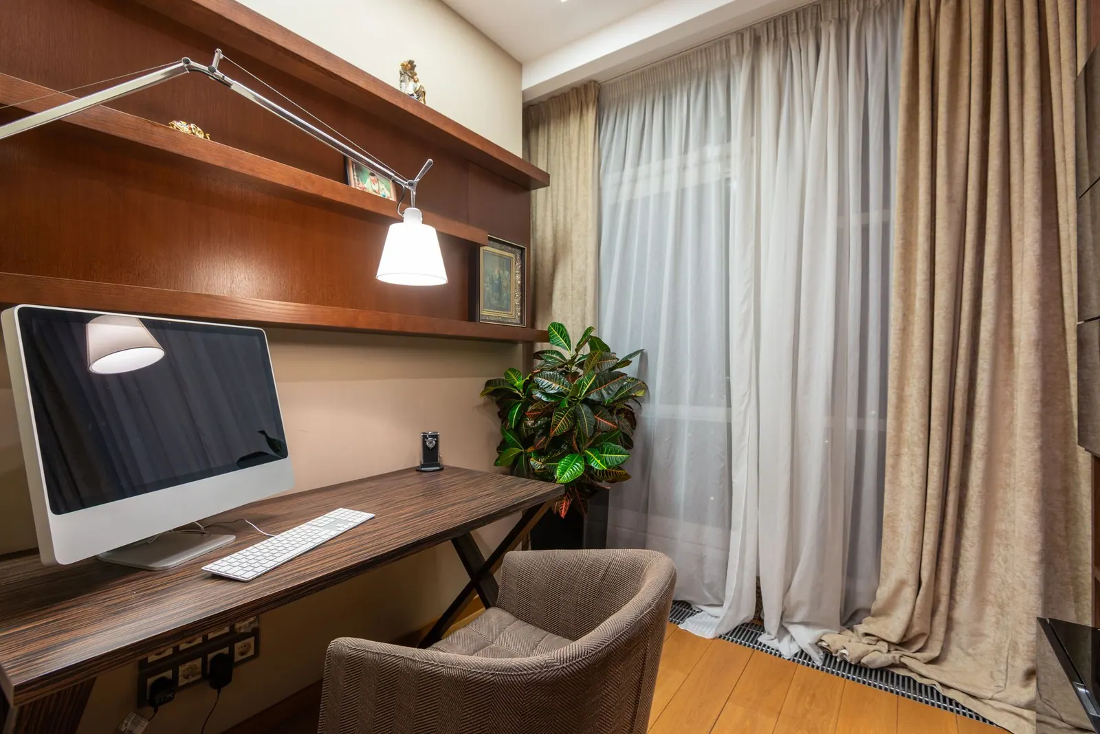 Interior of stylish room with computer placed on wooden table in modern apartment